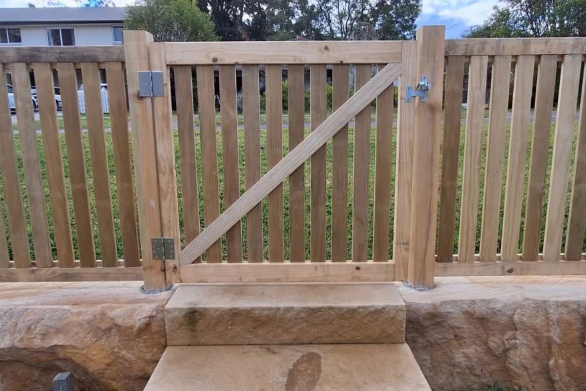Timber batten gate on sandstone retaining wall